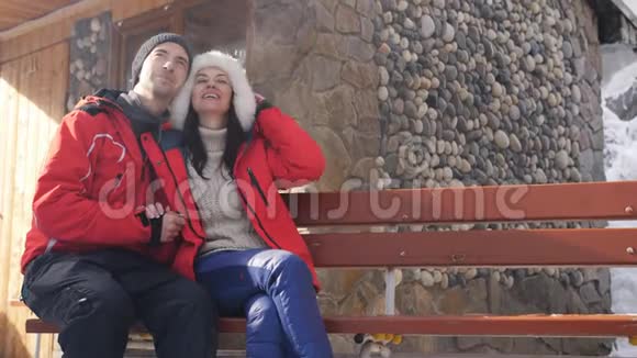 幸福相爱的一对夫妇坐在山里的冬夏莱特附近的长凳上视频的预览图