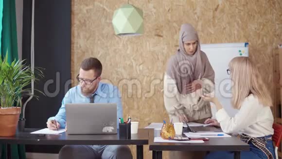穆斯林妇女正在帮助她的男女同事视频的预览图