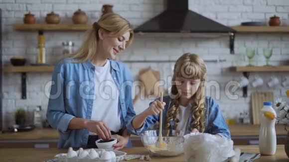 妈妈和女儿一起在厨房烤煎饼女孩帮她妈妈赚钱4K视频的预览图