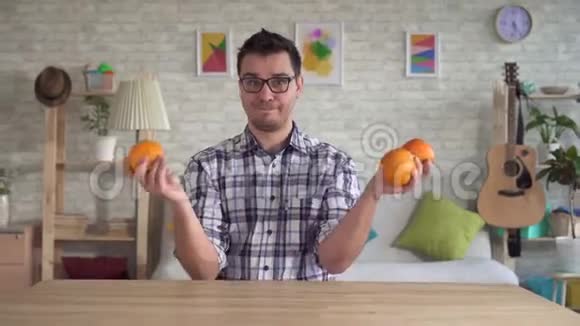 年轻人滑稽地扔橘子和杂耍橘子视频的预览图