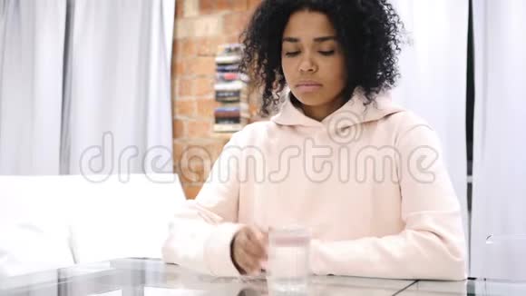 非洲裔美国妇女从玻璃中喝水和在笔记本电脑上工作的肖像视频的预览图
