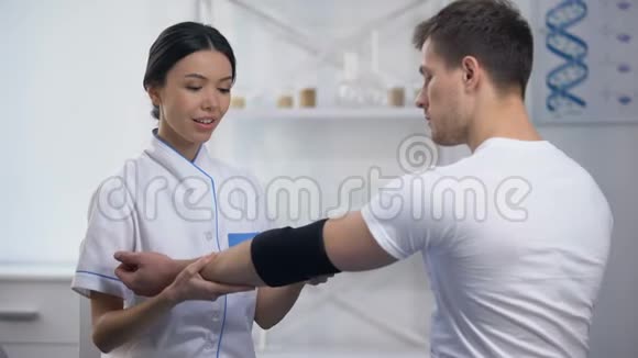 经验丰富的女性骨科医生应用肘垫矫形器运动员病人视频的预览图