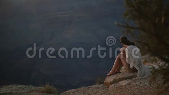 慢动作快乐的年轻成年女人头发在大风中吹着在雄伟的大峡谷欣赏史诗般的日落视频的预览图