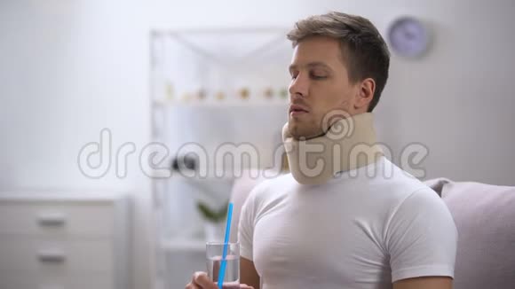 戴泡沫颈项圈的人试图用吸管喝玻璃水但企图失败视频的预览图