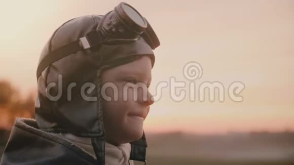 特写镜头滑稽的小男孩穿着旧的飞行员服装戴着围巾和眼镜在野外缓慢地做着愚蠢的表情视频的预览图
