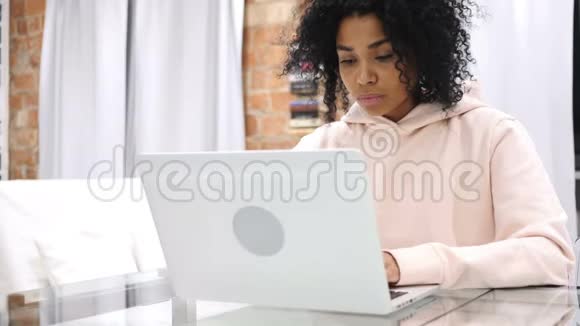 非裔美国妇女在笔记本电脑上工作时咳嗽的肖像视频的预览图