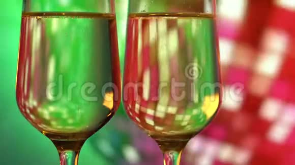 在明亮的迪斯科镜球背景上有两杯香槟视频的预览图
