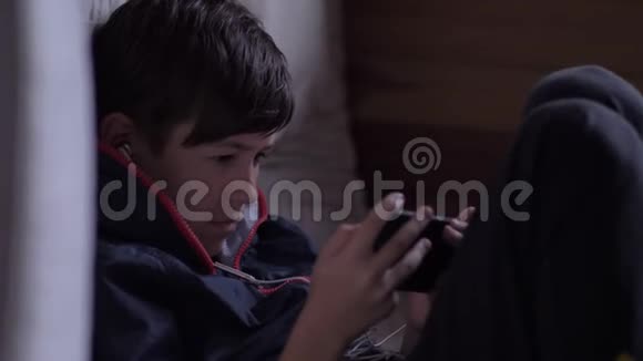 累坏了的男孩坐在dak角用电话伤心的男孩视频的预览图