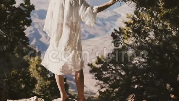 镜头倾斜在年轻的快乐旅游妇女穿着白色的裙子享受不可思议的大峡谷风景沙漠山景视频的预览图