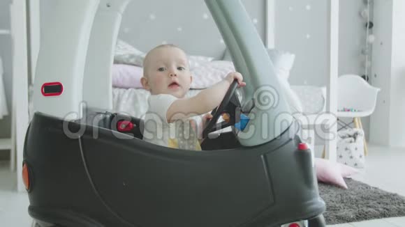 可爱的学步女孩在家开玩具婴儿车视频的预览图