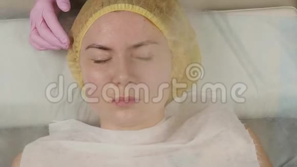 医生用蒸汽那个女人擦皮肤美容师皮肤有问题的年轻女人宇宙学的概念4K视频的预览图