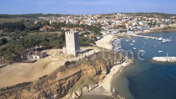 鸟瞰中世纪塔在NeaFokea海滩和一艘小船在港口Halkidiki希腊前进和向下视频的预览图
