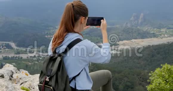 年轻女子在拍摄下面城市的照片视频的预览图