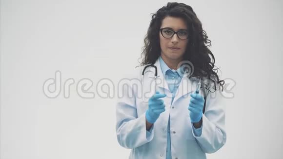 一位令人惊讶的年轻医生她穿着一件医用长袍手里拿着一个带着码头女人被隔离在灰色的视频的预览图