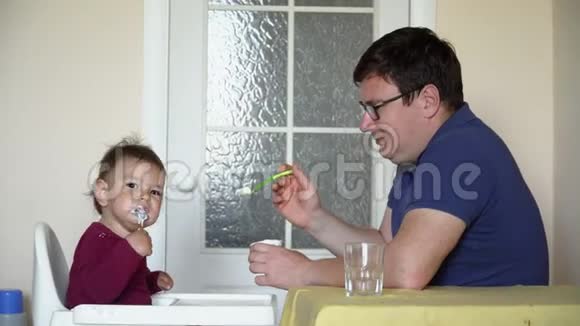 爸爸用勺子喂可爱的小女儿视频的预览图