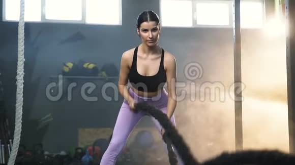 有魅力的适合女性在训练期间与战斗绳索在健身房视频的预览图