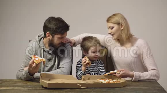一家人吃披萨的肖像热腾腾的披萨新鲜意大利经典原味意大利辣味披萨切片视频的预览图