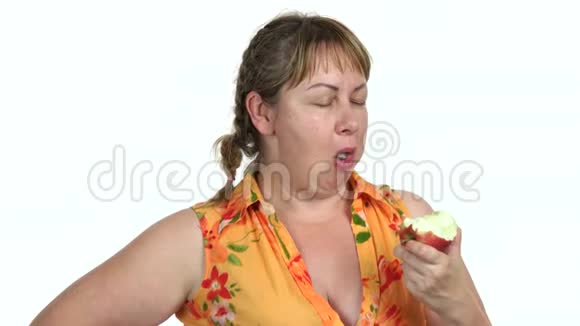 胖女人在白色背景下吃苹果视频的预览图