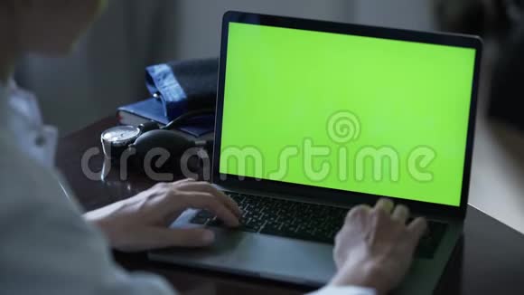未被确认的成功女医生在办公室的一张桌子旁用绿色屏幕在笔记本电脑上打字视频的预览图