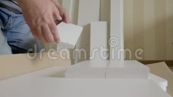 在组装前一个箱子取出白色木制家具的元素视频的预览图