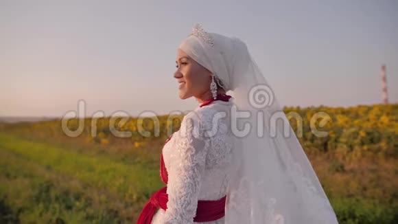 一个穿着白色国服的漂亮女孩站在田野里看着夕阳然后转身走向摄像机视频的预览图