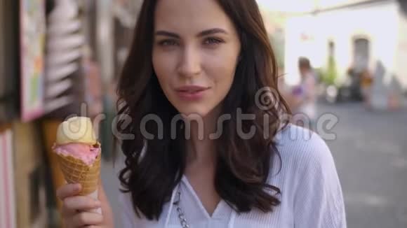 美丽的黑发女人吃美味可口的冰淇淋视频的预览图