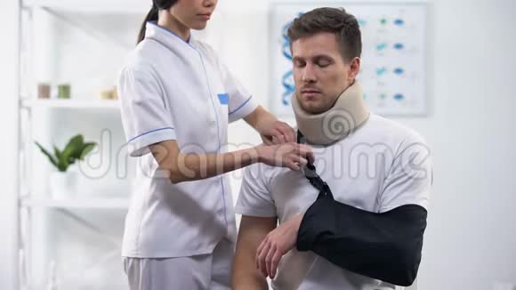 矫形师将男性病人手臂吊索固定在正确的位置创伤后康复视频的预览图