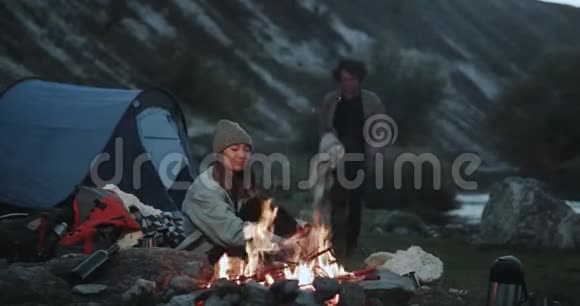 日本小姐和男朋友一起度过浪漫的夜晚在篝火旁露营小伙子带了一条毯子视频的预览图