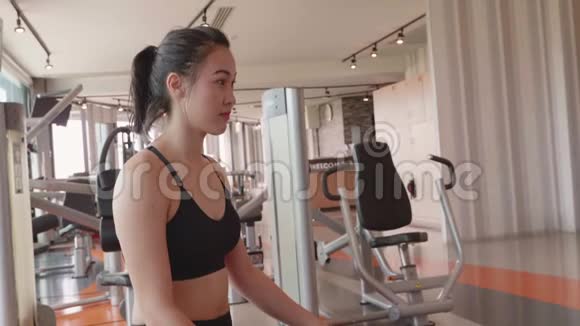 有魅力的亚洲女孩在健身运动健身房从瓶子里喝水享受淡水的年轻妇女的特写视频的预览图