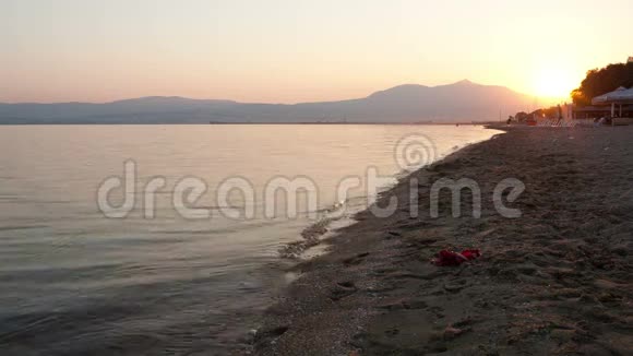 日落时沿着海滩奔跑的人视频的预览图