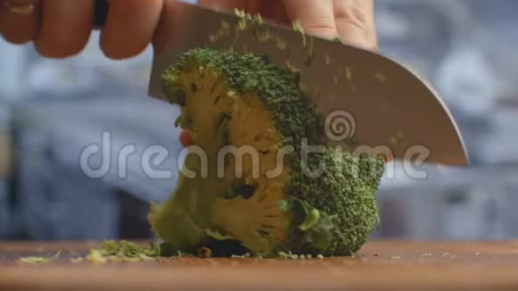 用刀切在厨房里的木板特写西兰花上切碎视频的预览图
