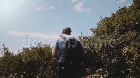 中年游客带着摄影师背包在美丽的绿色灌木丛中徒步旅行到比克斯比大桥的史诗般的风景视频的预览图