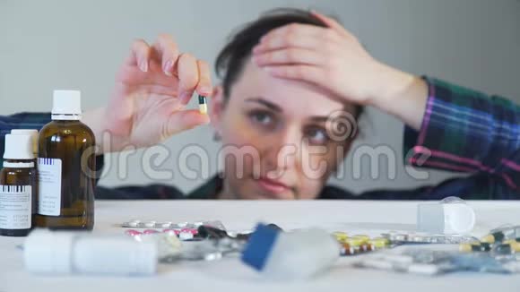 年轻女子拿着药丸看着它视频的预览图