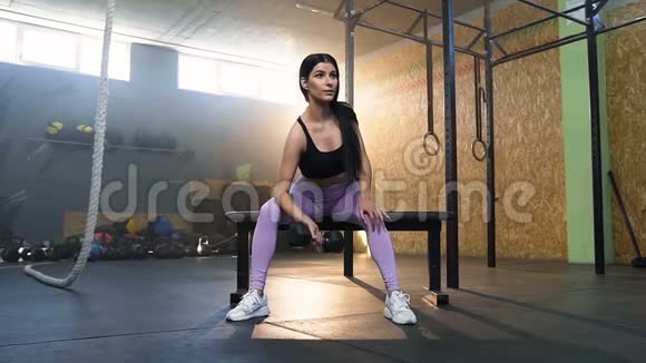 漂亮的适合女性训练手使用哑铃在健身房视频的预览图