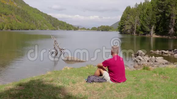 游客坐在湖边拍照视频的预览图