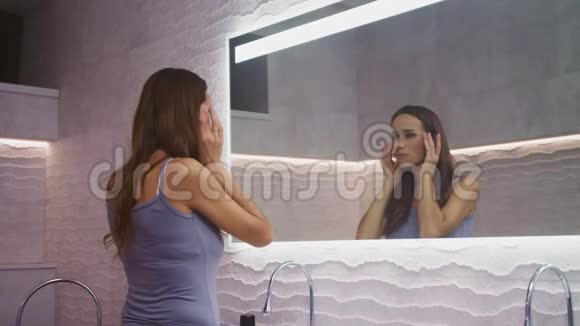 漂亮的女人在浴室里按摩脸做面部瑜伽的漂亮女人视频的预览图