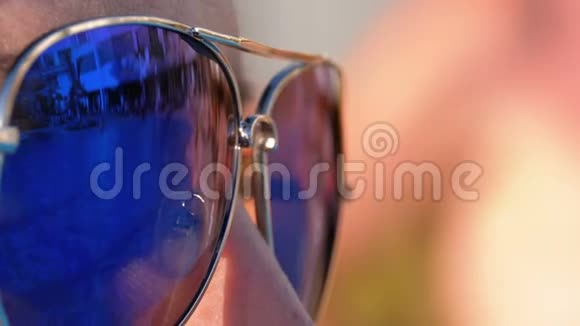 女孩脸上的太阳镜特写和眼镜中游泳池的倒影视频的预览图