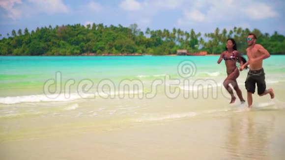 慢镜头异族幸福夫妻在阳光明媚的夏日在热带海滩享受蜜月视频的预览图