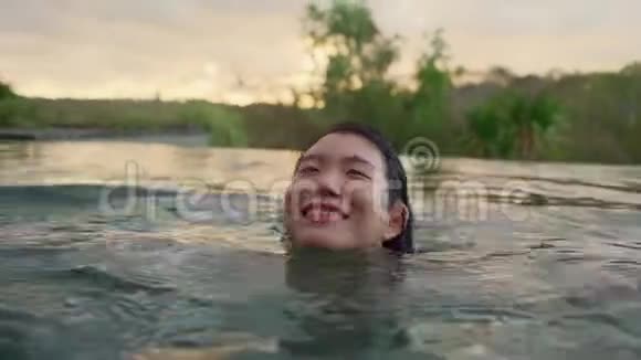 Olidays的生活方式拍摄于一位年轻美丽放松的亚洲女性她在热带旅游胜地游泳池欣赏风景视频的预览图