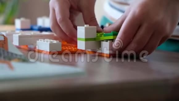可爱的男孩6岁在家里的桌子上玩五颜六色的塑料玩具砖关门了视频的预览图