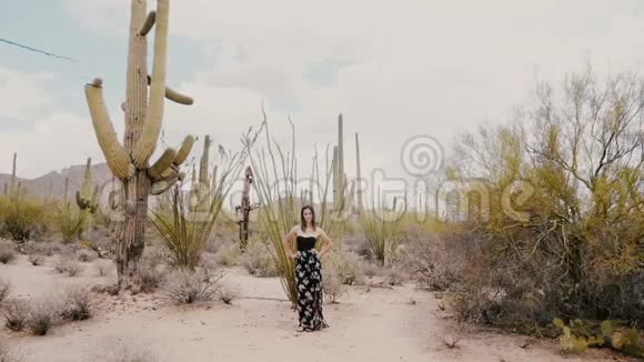 慢镜头宽镜头年轻美女摆姿势看镜头大野野萨瓜罗仙人掌国家公园沙漠美国视频的预览图