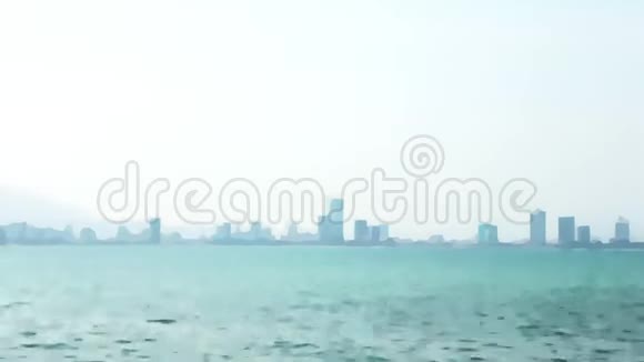 摩天大楼的轮廓在雾和海洋模糊的背景视频过渡薄雾笼罩着大海和城市摩天大楼视频的预览图