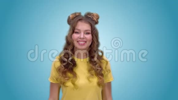 漂亮的年轻女孩穿着一件黄色衬衫露出禁止的姿态看着镜头微笑视频的预览图