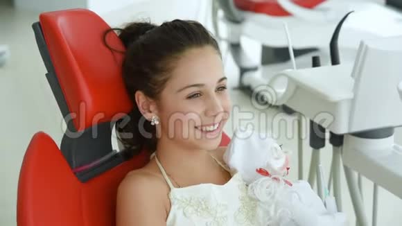 一位戴红牙椅的女婴在牙科医生接待处视频的预览图