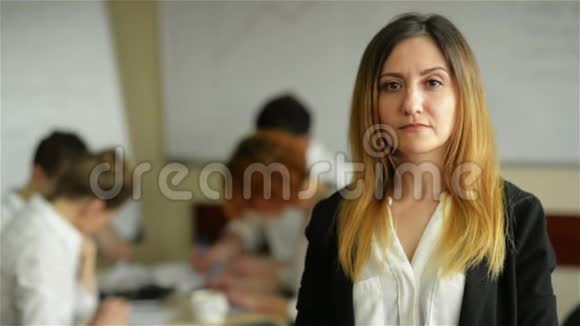 漂亮的年轻的咧嘴笑着的职业女性在其他员工开会时充满自信的表情视频的预览图