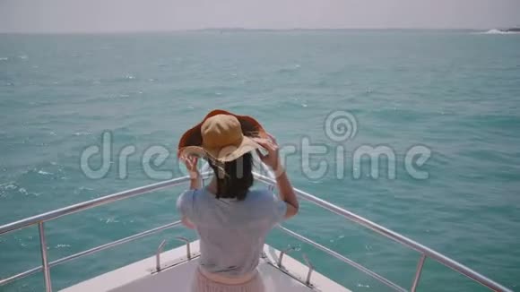 阳光明媚的海上巡游中快乐的游客女子站在游艇前鼻的美丽慢动作后视照片视频的预览图