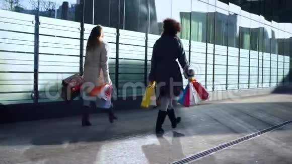 两个手里拿着袋子的女朋友走在街上视频的预览图