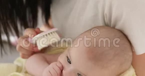 年轻微笑的女人梳头宝宝特写视频的预览图