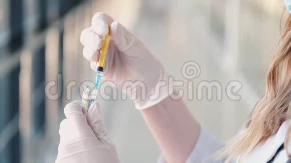 医用手套护士正在用黄色溶液测试注射器视频的预览图