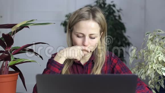 年轻女孩在笔记本电脑屏幕前担心视频的预览图